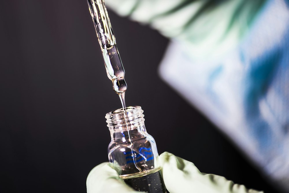 Gloved hand drawing medicine from a vial